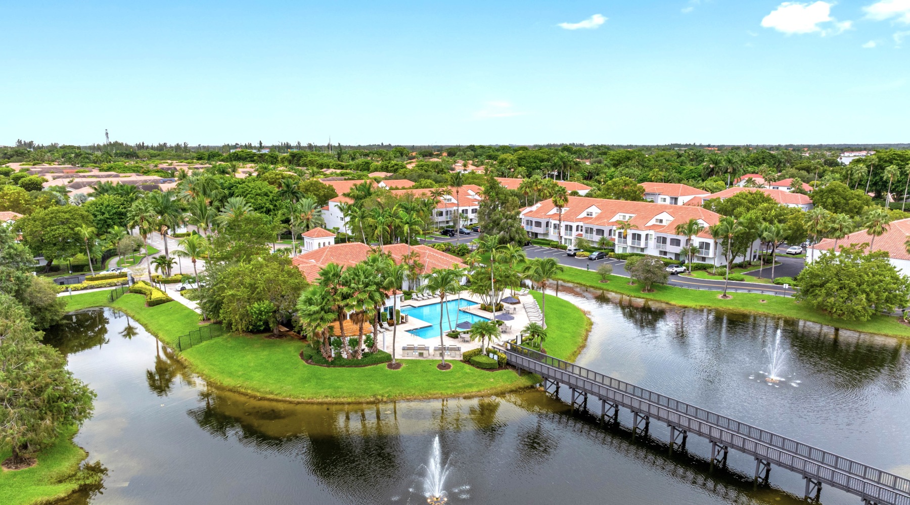 Aerial view of The Palms of Doral community lake, pool, and pedestrian bridge, showcasing the resort-like environment in Doral, FL 33178. Aerial view of The Palms of Doral community lake, pool, and pedestrian bridge, showcasing the resort-like environment in Doral, FL 33178.
